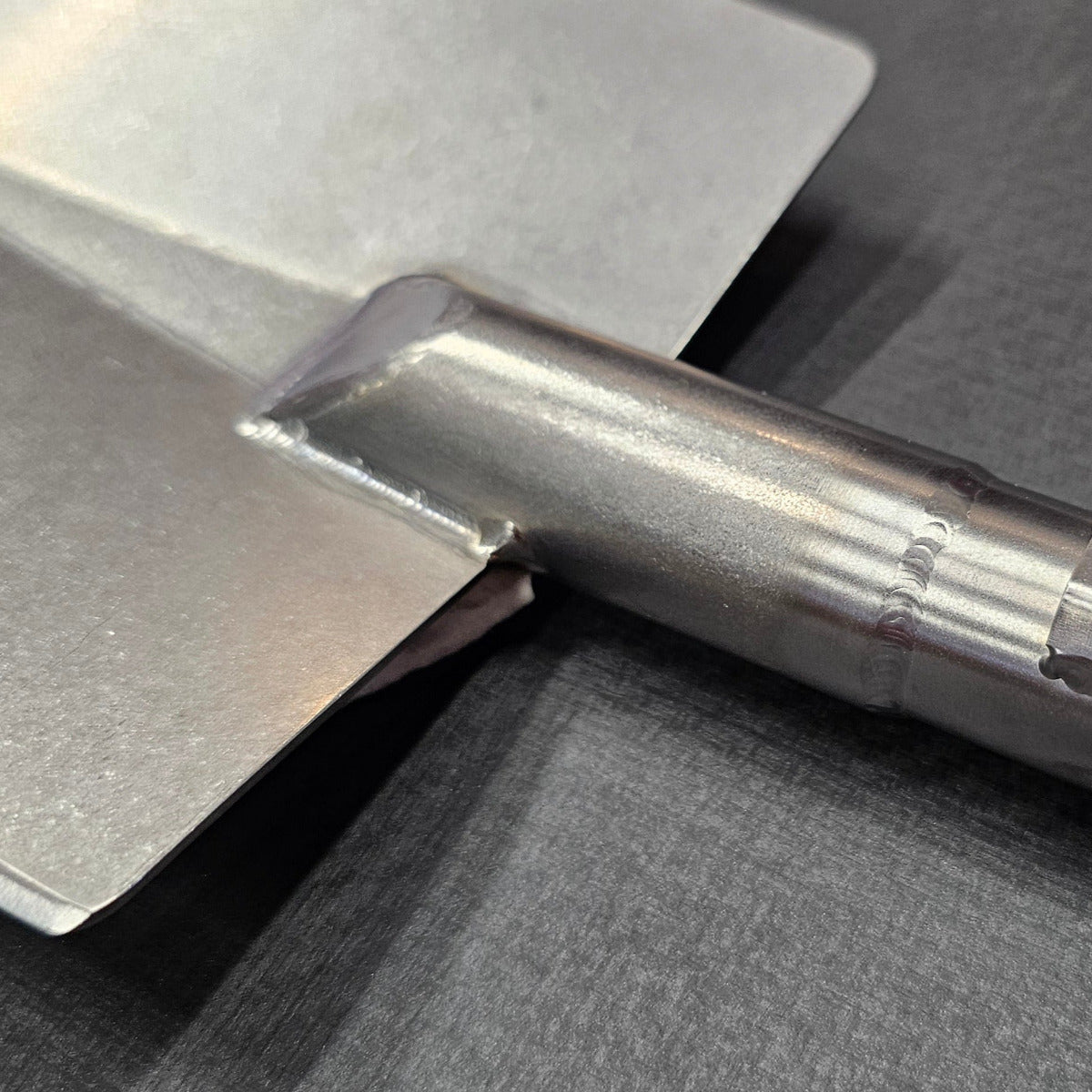 titanium shovel with 'Brautigam Expedition works' branding on a dark background