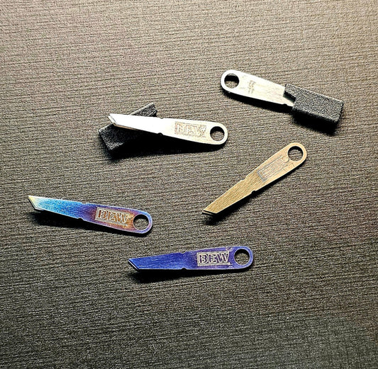 Set of small titanium tweezers with 'BEW' branding on a textured surface