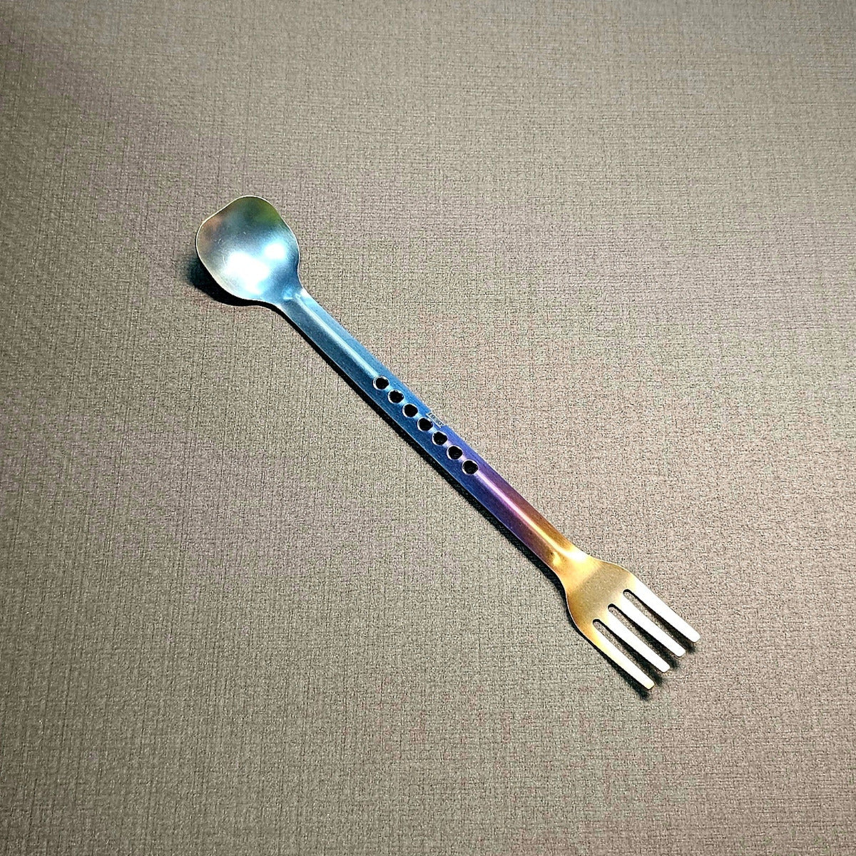 Metallic spoon and fork on a textured gray background