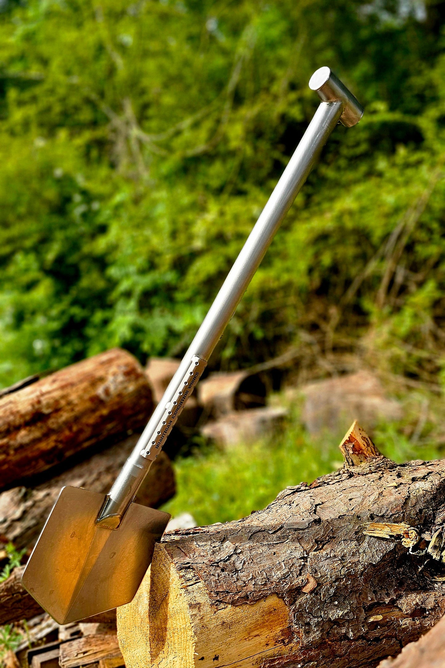 Shovel on a stack of logs with a forest background