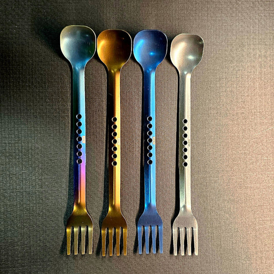 Five metal utensils with fork-like ends on a textured surface